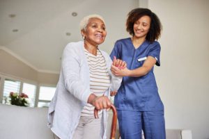 : Professional caregiver sharing a conversation with an elderly woman at home.